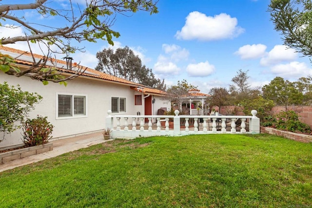 back of property featuring a pergola and a lawn