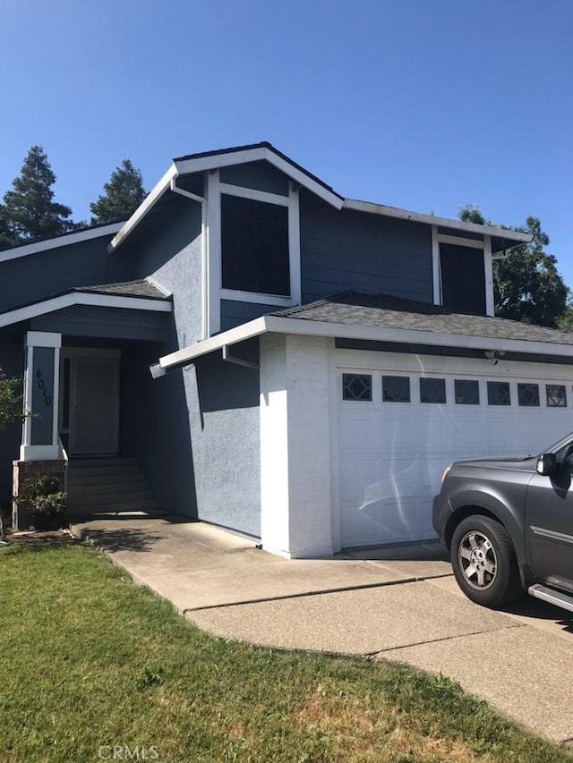 view of property exterior with a garage and a lawn