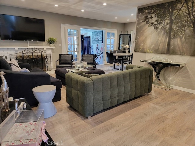 living room with a fireplace and light wood-type flooring