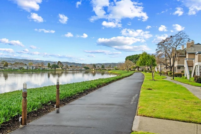 surrounding community with a yard and a water and mountain view