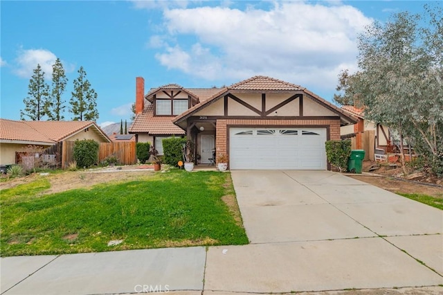 tudor house with a chimney, an attached garage, a front yard, fence, and driveway