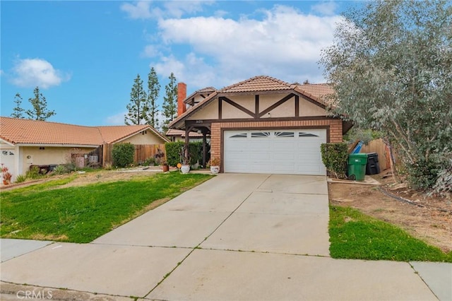 tudor home featuring an attached garage, fence, concrete driveway, stucco siding, and a front yard