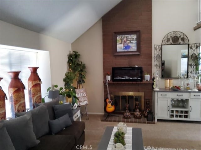 living area with a brick fireplace, light colored carpet, and vaulted ceiling