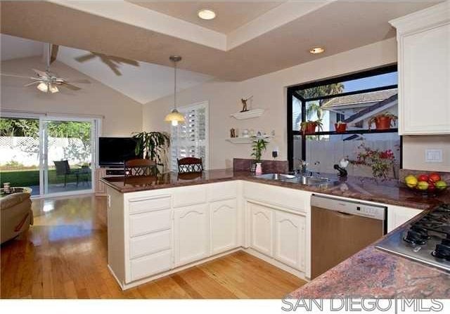 kitchen featuring sink, kitchen peninsula, stainless steel appliances, light hardwood / wood-style floors, and white cabinets