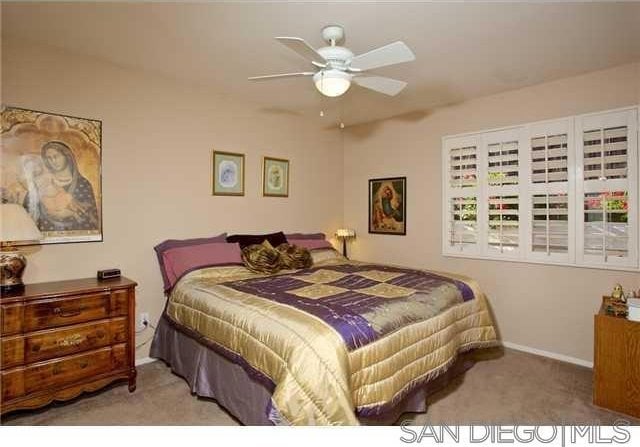 bedroom with ceiling fan and light carpet