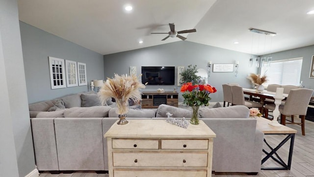 living room featuring vaulted ceiling, ceiling fan, and light hardwood / wood-style flooring