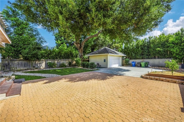 view of front of home featuring an outbuilding, a front lawn, fence, and a garage