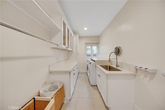 washroom featuring light tile patterned floors, a sink, recessed lighting, cabinet space, and washing machine and dryer