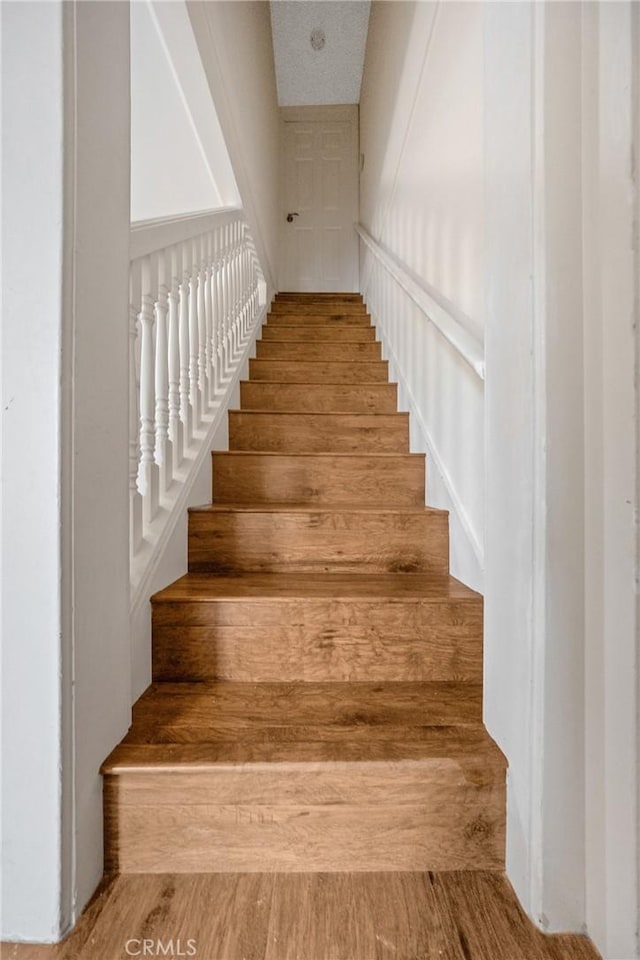 stairs featuring wood finished floors