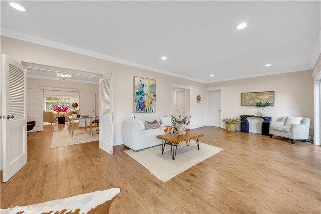 living area with light wood-style flooring, crown molding, baseboards, and recessed lighting