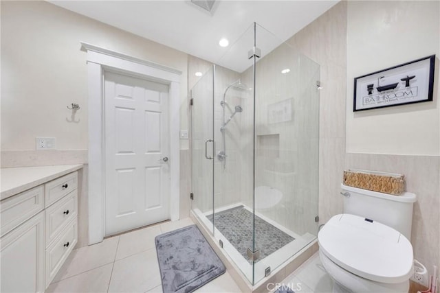 bathroom with toilet, tile patterned floors, vanity, and a stall shower