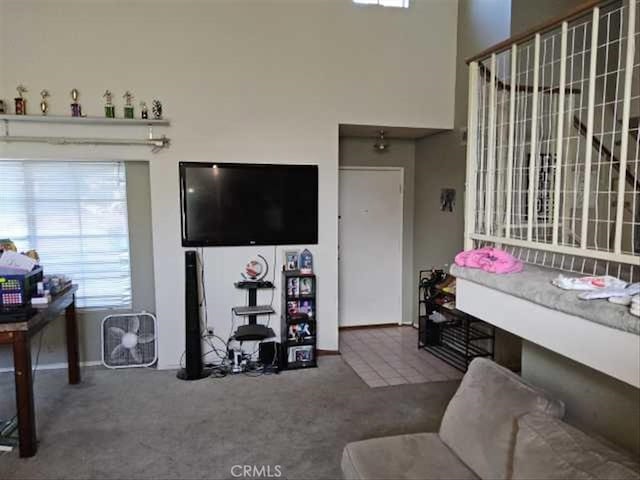 carpeted living room featuring a towering ceiling