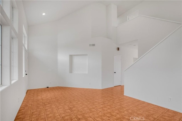 empty room featuring a towering ceiling