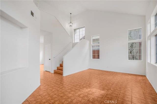 unfurnished living room with high vaulted ceiling