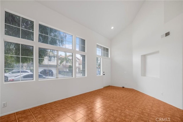 spare room with high vaulted ceiling