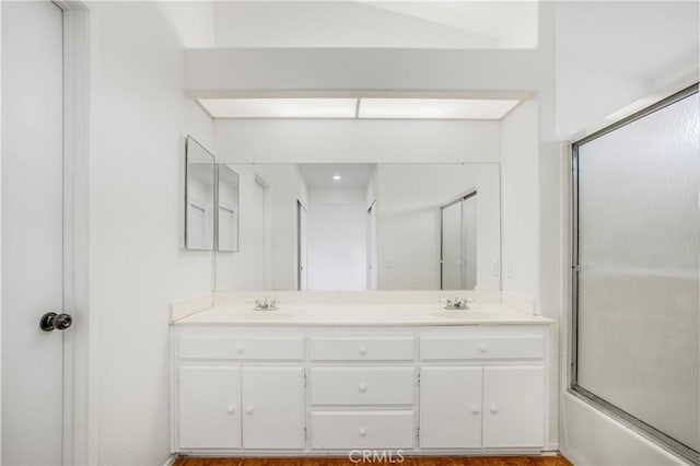 bathroom featuring enclosed tub / shower combo and vanity