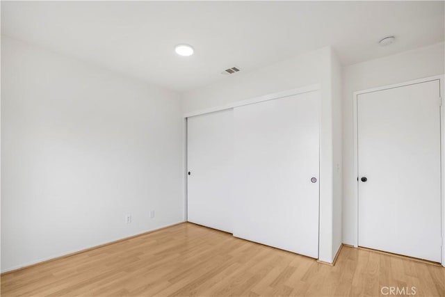 unfurnished bedroom featuring a closet and light hardwood / wood-style flooring