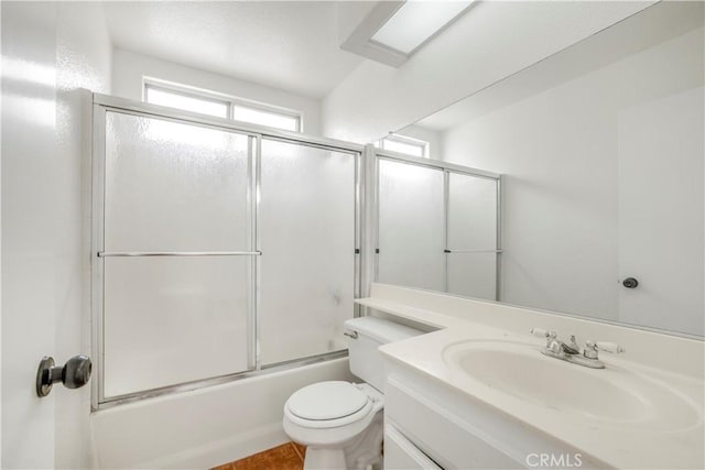 full bathroom with vanity, shower / bath combination with glass door, and toilet