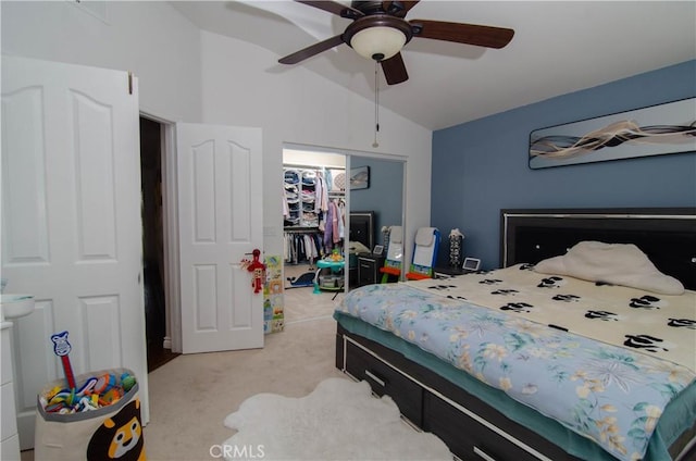 bedroom with a closet, a spacious closet, lofted ceiling, ceiling fan, and light carpet