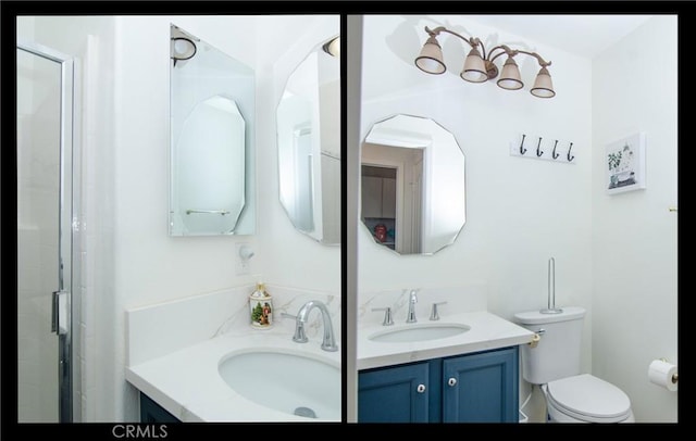 bathroom featuring toilet, vanity, and a shower with shower door