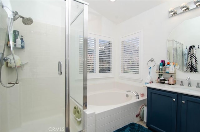 bathroom with vanity and shower with separate bathtub