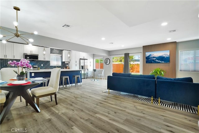 living room featuring a chandelier and light hardwood / wood-style flooring