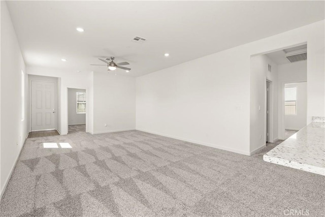 carpeted empty room with plenty of natural light and ceiling fan