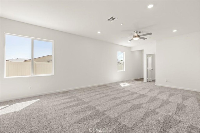 carpeted spare room with plenty of natural light and ceiling fan