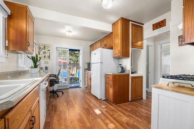 kitchen featuring white appliances, sink, and light wood-type flooring