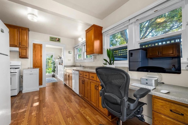 kitchen featuring wood-type flooring, sink, and white appliances