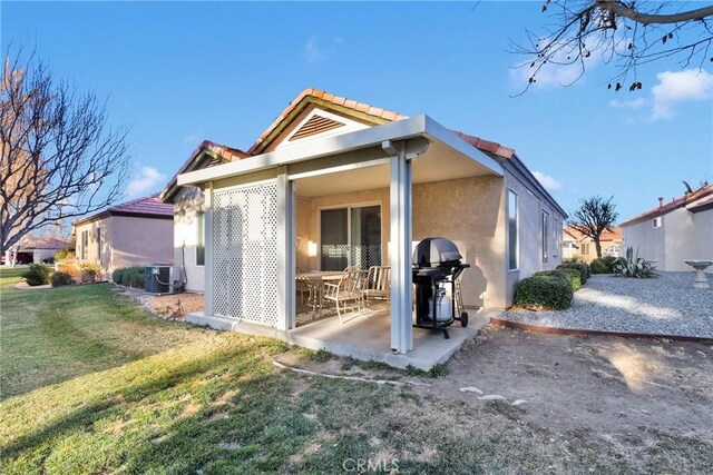 rear view of property featuring a yard, a patio, and central air condition unit