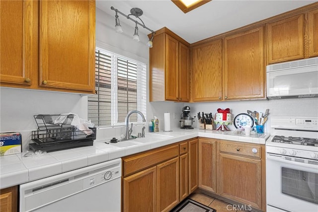 kitchen featuring sink, tile countertops, and white appliances