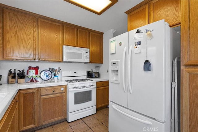 kitchen featuring white appliances, tile countertops, and light tile patterned floors