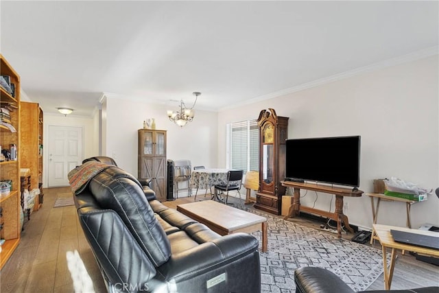 living room featuring crown molding, a chandelier, and light wood-type flooring