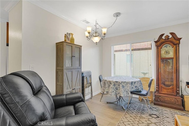 dining room with ornamental molding, light wood-type flooring, and a notable chandelier