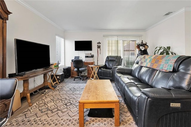 living room featuring ornamental molding, a healthy amount of sunlight, and light wood-type flooring