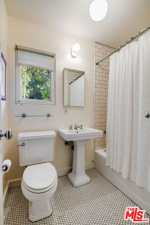 bathroom featuring toilet and shower / bath combo