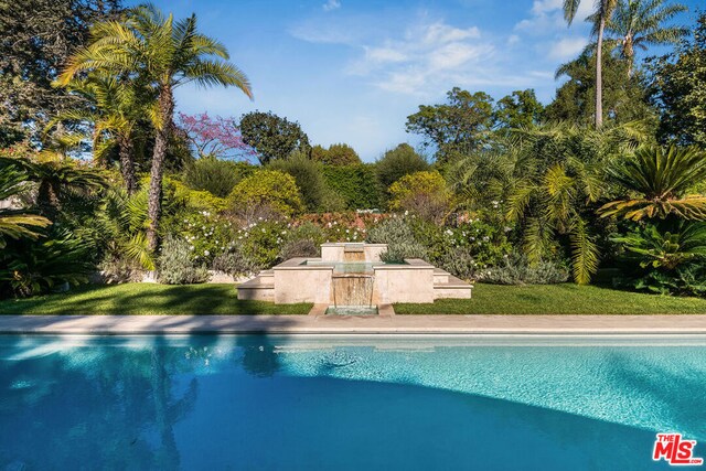 view of pool featuring a lawn