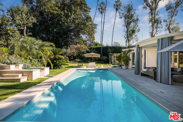 view of pool featuring a hot tub and a patio area