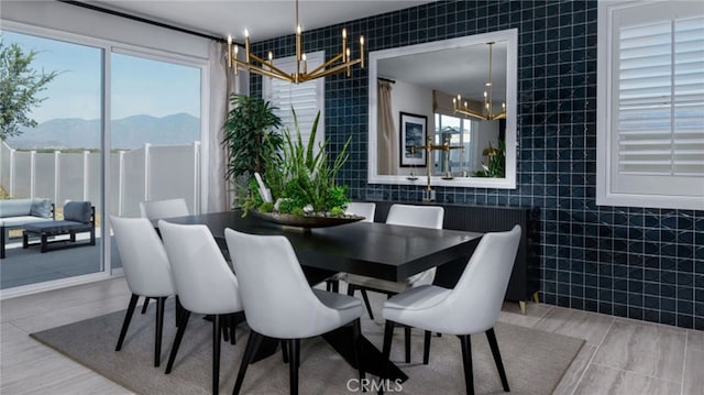 dining room with tile walls, a mountain view, and an inviting chandelier