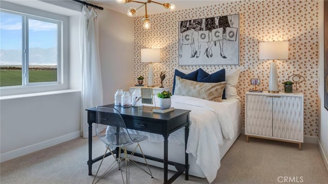 bedroom with an inviting chandelier and light colored carpet