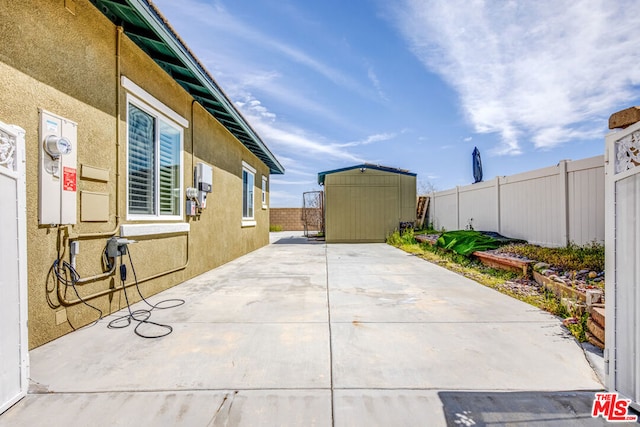 view of home's exterior with a shed and a patio