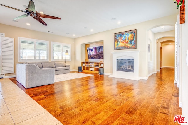 unfurnished living room featuring ceiling fan and light wood-type flooring