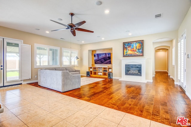 unfurnished living room featuring light tile patterned floors and ceiling fan