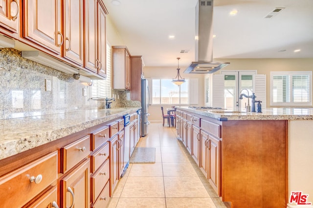 kitchen with island range hood, decorative light fixtures, light tile patterned floors, stainless steel refrigerator, and backsplash