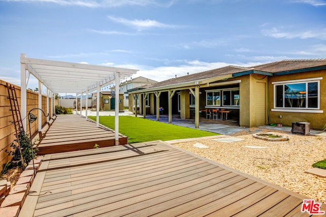 wooden terrace with a pergola, a patio, and a lawn