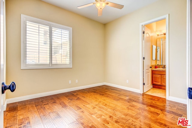 bedroom with ensuite bath and light hardwood / wood-style flooring