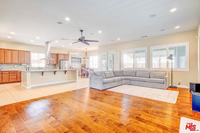 unfurnished living room with light hardwood / wood-style floors and ceiling fan