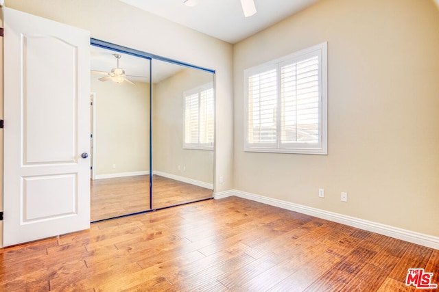 unfurnished bedroom with light hardwood / wood-style floors, a closet, and ceiling fan