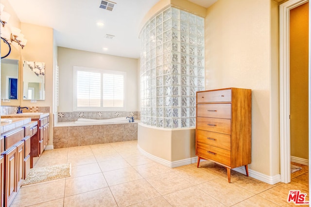 bathroom with vanity, tile patterned flooring, and tiled tub